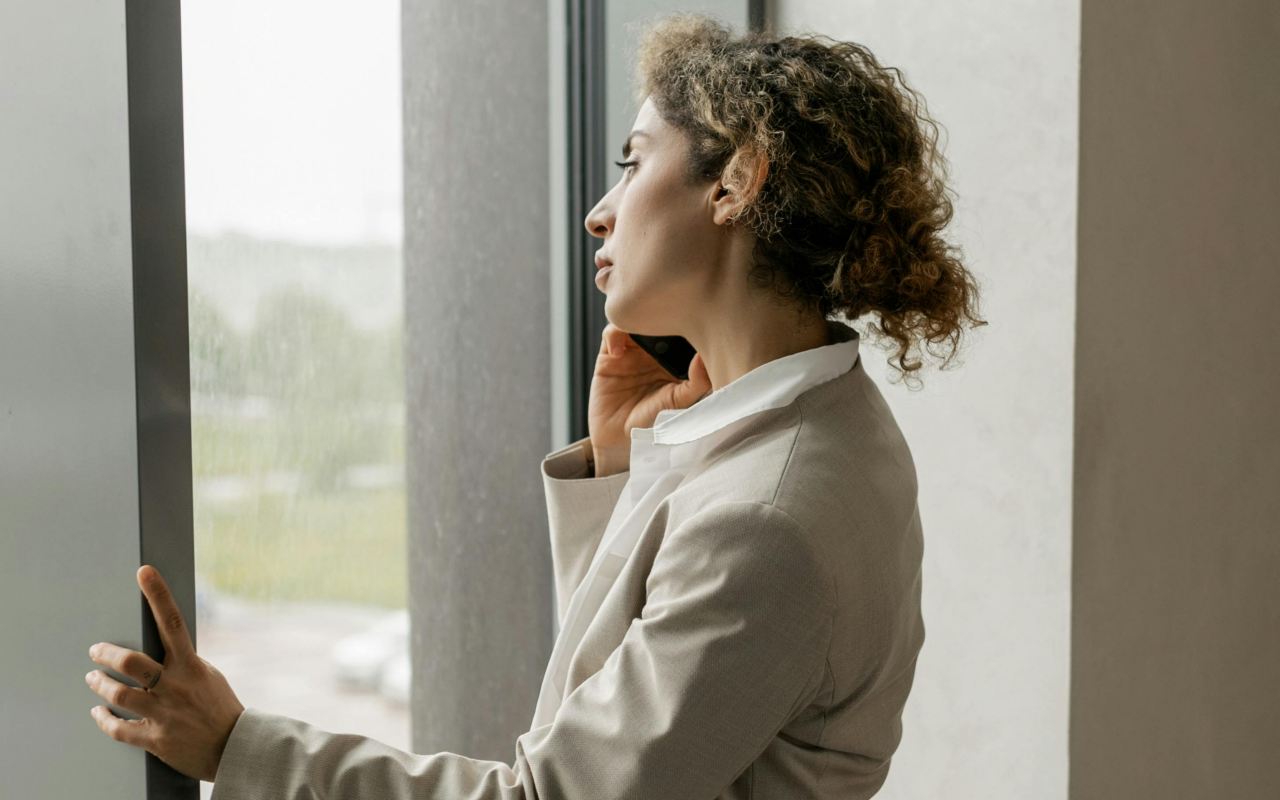 Žena u bež odelu razgovara telefonom