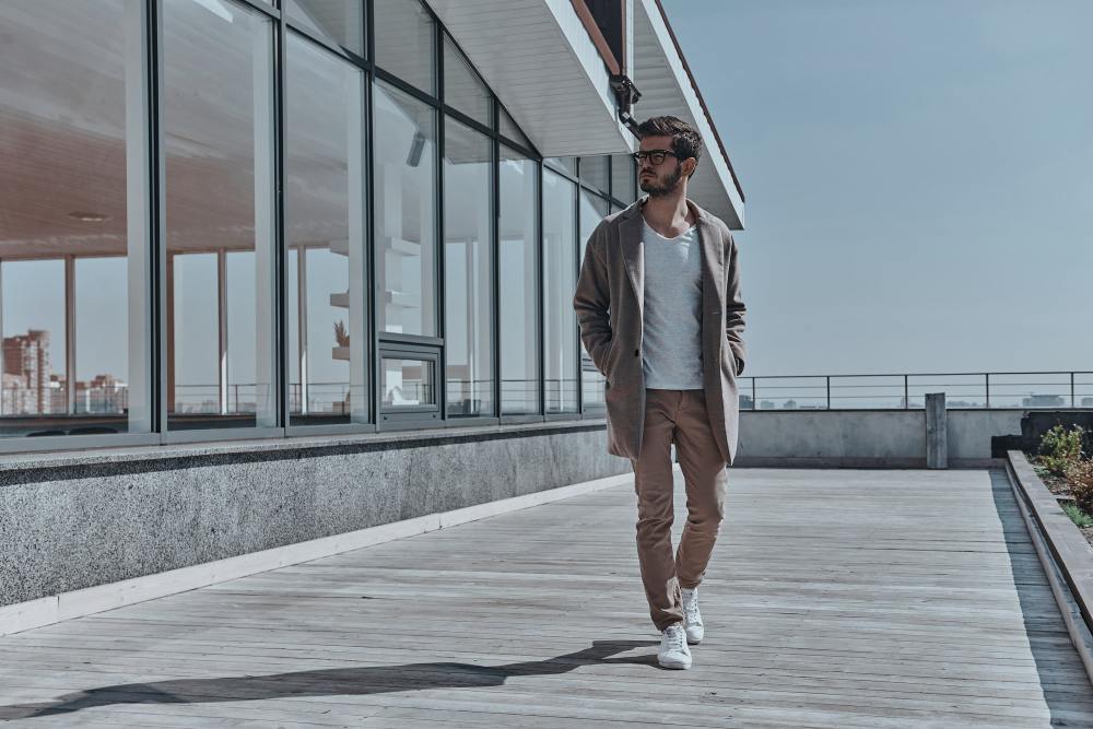 muskarac u pokretu u sportskom sakou i patikama