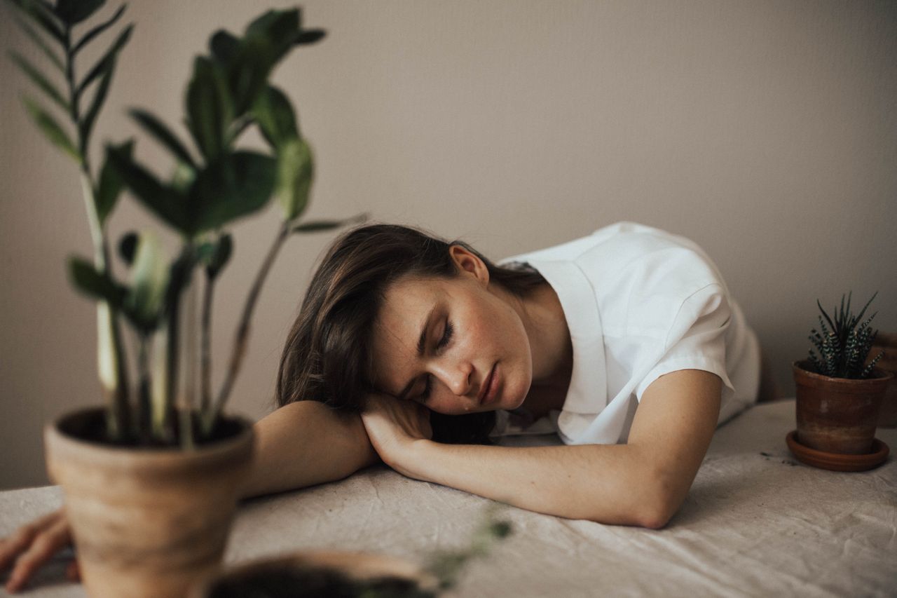 Umorna osoba odmara glavu na stolu